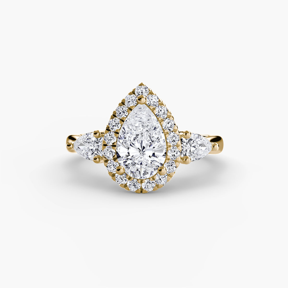 Isolde Pear Three-Stone Halo in yellow gold