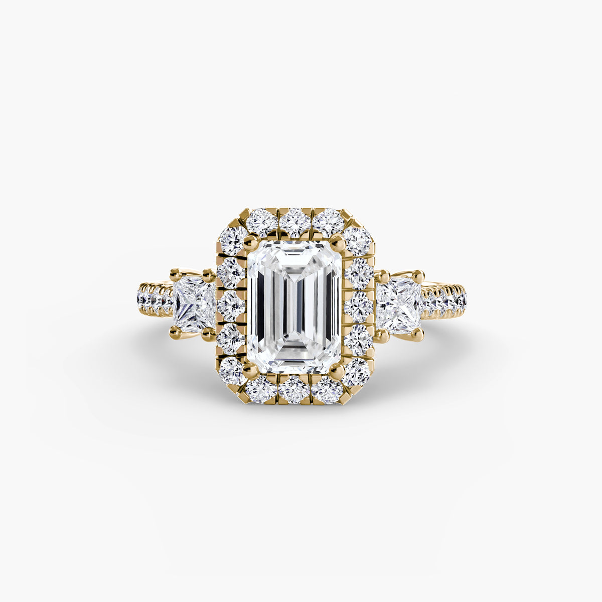 Guinevere Emerald Three-Stone Halo in yellow gold